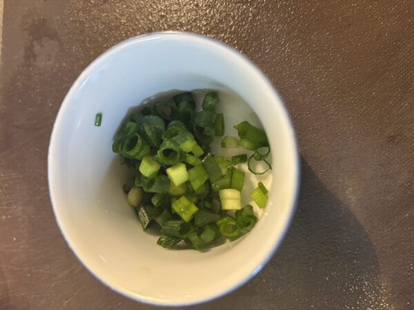 鶏肉にしめじと根菜のブイヨン煮を加え、中火で炒め合わせている様子