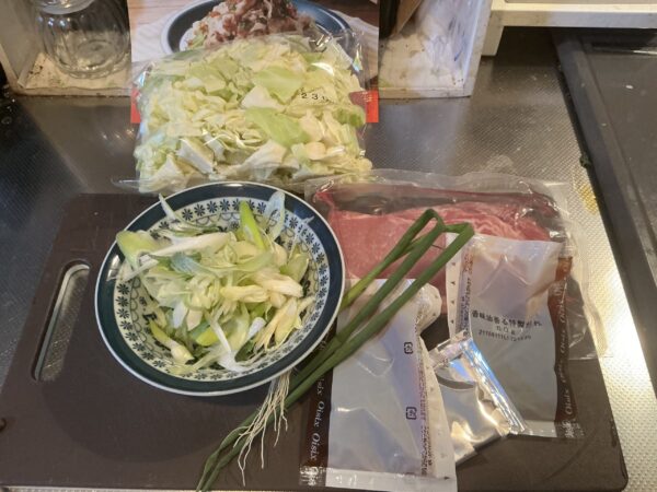 ミールキットの袋から中身を取り出し、野菜を水洗いして準備する様子