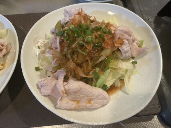 完成した豚眠菜園。キャベツと豚肉に特製ネギだれがたっぷりかかった様子