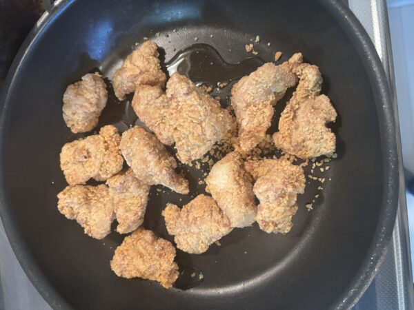 フライパンに油を引き、唐揚げに焼き色がつくように炒める調理工程