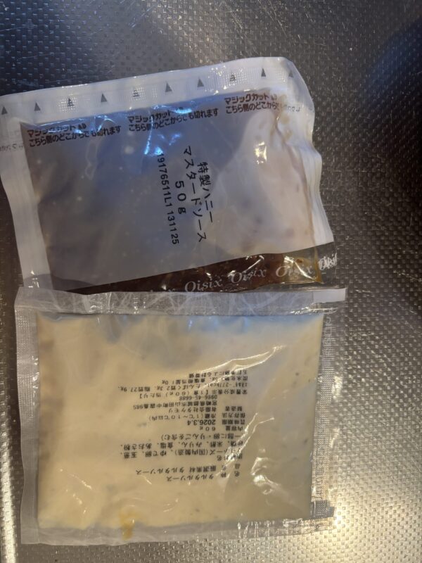 焼き上がったチキンを器に盛り、タルタルソースとハニーマスタードソースをかける様子